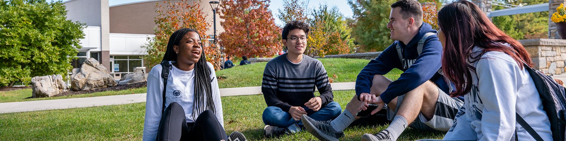 Group of students sitting in the grass in Perkins Plaza